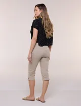 Pantalón capri blanco de tiro alto, corte entallado y silueta ajustada, con pretina ancha elastizada sin cierres, bolsillos simulados al frente y pequeños tajos en los ruedos.