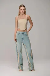 Corselet de estilo corset con tiras finas, escote recto y bajo curvo. Presenta costuras verticales que estructuran la prenda, brindando un ajuste entallado y una silueta definida.