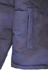 Campera acolchonada con efecto tie-dye en tonos azul y negro, cuello alto, cierre frontal con cremallera y bolsillos laterales. Cuenta con puños elásticos para mayor ajuste.