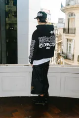 Hoodie negro con cierre, corte regular y lavado gastado. Estampado con logo en el pecho y diseños en las mangas.