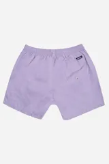 Short de baño color mostaza, de tela ligera y secado rápido, con cintura elástica y cordón de ajuste blanco. Posee bolsillos laterales y uno trasero, y un pequeño logo de goma en la parte inferior derecha.