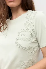 Remera de manga corta color crudo con apliques florales bordados tono sobre tono en el frente.