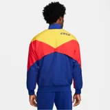 Chaqueta deportiva Nike del F.C. Barcelona, con cierre frontal completo y cuello alto. Diseño color azul con bloques en rojo y amarillo en las mangas, e incluye el logo de Nike y el escudo del club bordados.