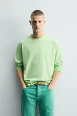 Camiseta de manga larga color verde lima, corte regular fit y cuello redondo. Presenta un bordado discreto en la espalda.