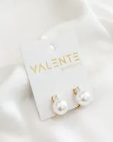 Par de caravanas doradas con clip, con una perla blanca y un strass pequeño.