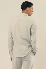 Pantalón celeste a rayas verticales blancas, confeccionado en tejido de algodón. Con cintura elastizada y cordón de algodón para regular el calce.