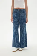 Pantalon de jean de tiro alto con corte ancho y estampado floral en tonos azules. Cuenta con bolsillos laterales y traseros.