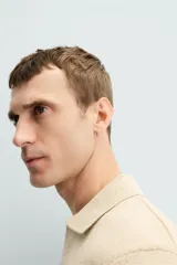 Polo color beige de punto con cuello solapa y manga corta.