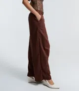 Pantalón de corte barrel con piernas anchas y cintura elástica, confeccionado en tejido técnico de poliéster y poliamida.