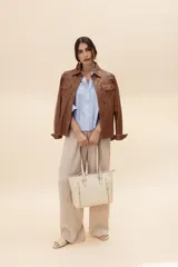 Camisa de cuero vacuno genuino color beige, de estilo Western, con bolsillos de parche con solapa en el pecho, costuras pespunteadas a contratono y botones metálicos frontales.