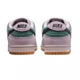 Championes Nike SB Dunk Low de gamuza en color verde oscuro y rosa claro, con el swoosh en azul marino oscuro y suela de goma color caramelo.