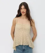 Blusa peplum de encaje color beige, con tirantes finos, escote cuadrado y busto fruncido.