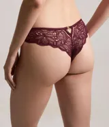 Bombacha tipo bikini confeccionada en encaje con textura floral y transparencias delicadas. Presenta un diseño elegante con acabado suave en la cintura y piernas, y forro interior de algodón.