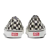 Championes Vans Authentic con estampado a cuadros en blanco y negro, cordones blancos y suela de goma blanca con línea negra.