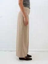 Pantalón de vestir color beige con finas rayas verticales, corte palazzo y tiro alto.