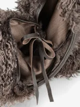 Cartera de diseño amplio y estructura flexible, confeccionada en textura de pelo sintético que aporta volumen. Cuenta con asas cortas integradas para llevar al hombro o en la mano.