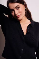 Cardigan marrón de punto acanalado con cuello polo, manga larga y cierre frontal con botones.