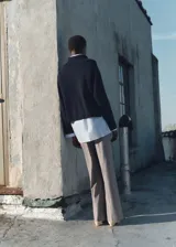 Pantalon de vestir de corte wide leg y tiro medio, confeccionado en tejido fluido. Presenta trabillas para cinturón, bolsillos laterales y cierre oculto con botón, gancho y cremallera.