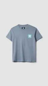 Camiseta de manga corta color verde azulado, corte holgado, con un pequeño estampado cuadrado con una 'X' en el pecho.