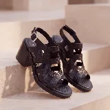 Sandalias de cuero color marrón, con taco ancho, diseño de tiras cruzadas y hebilla metálica de ajuste en el tobillo.