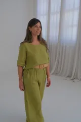 Pantalón de lino verde lima, de corte recto y tiro medio, con cinturón beige de soga incluido.