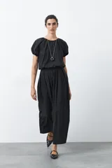 Falda larga plisada color negro, de silueta amplia y caída fluida, con cintura elástica.