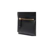 Mochila Tom Ford modelo Buckley, color negro de textura granulada, con cierre principal de doble cremallera y un bolsillo frontal con cierre metálico dorado. Cuenta con asa superior y diseño elegante y funcional.