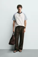 Camiseta de hombre regular fit, color blanco con mangas raglán cortas en azul claro y cuello redondo en rib azul marino.