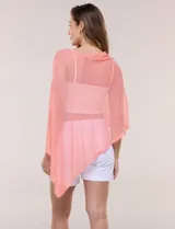 Poncho liviano de tejido de punto fino calado, color blanco, con silueta asimétrica envolvente, escote bote drapeado y mangas integradas estilo capa.