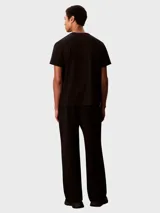 Pantalón de felpa negro Calvin Klein, de corte regular y pierna recta, con costuras delanteras decorativas y logo bordado en el muslo.