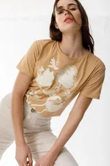 Remera lila de algodón con estampado de flores en tonos naranja y rosa.