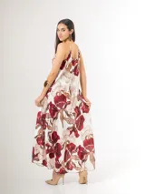 Vestido largo de satén azul marino con tirantes finos y escote en V, con gran estampado floral en tonos blancos, celestes y marrones, y diseño de caída fluida.