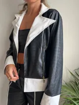 Campera de cuero sintético negra con textura de cocodrilo, con cuello, solapas y puños en color blanco.