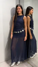 Conjunto azul marino compuesto por un top sin mangas de cuello redondo y frunces laterales, y una falda larga de tiro alto con diseño translúcido en la parte inferior.