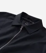 Campera masculina de corte boxy en color beige, con cuello inglés, cierre frontal de cremallera, mangas largas con puños elásticos y ruedo con elástico. Presenta bolsillos laterales y detalles de recortes en el diseño.