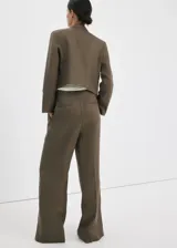 Pantalón de lino verde militar, de diseño recto y tiro alto, con detalle de pinzas y trabillas en la cintura.