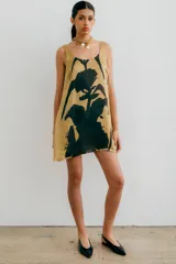 Vestido corto color beige con estampado floral abstracto en negro, de corte recto y sin mangas.