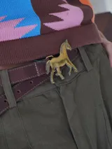 Cinturón de cuero marrón con hebilla metálica dorada en forma de caballo.