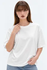 Remera blanca de manga corta, cuello redondo a la base y diseño holgado.