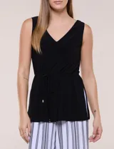 Enterito de efecto dos piezas con parte superior negra lisa, escote en V y sin mangas, y parte inferior de pantalón palazzo de corte amplio con diseño a rayas en blanco y negro. Cuenta con cintura entallada con lazo ajustable.