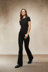 Jean de corte oxford en color negro, con tiro medio y ajuste en la cintura y caderas, ensanchándose desde la rodilla hacia el ruedo.