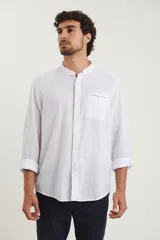 Camisa de cuello mao y manga larga, confeccionada en una mezcla de lino y algodón. Presenta un diseño de corte recto con botones en tono natural y un bolsillo pequeño en el pecho.