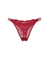 Tanga de encaje rojo con tiro bajo y tiras laterales elásticas con pedrería brillante y el logo de la marca.