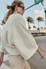 Jersey de punto liso color azul, con cuello redondo, botones delanteros y manga ancha por debajo del codo.