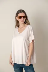 Remera holgada color beige, de escote en V y mangas cortas.