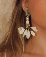 Aros colgantes con forma de lágrima color crema y detalles dorados.