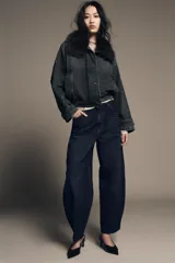 Chaqueta tipo bomber de denim lavado azul, corte holgado, con cuello solapa y aplicación de pelo sintético marrón desmontable. Presenta bolsillos delanteros y bajo acabado en elástico.