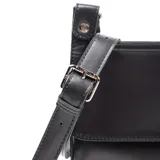 Bandolera pequeña de cuero color negro, con diseño de solapa frontal y correa ajustable. Presenta el logo de la marca en una placa metálica en la parte inferior central.