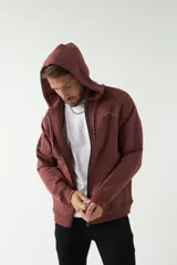 Campera de felpa negra con capucha y cordón ajustable, cierre frontal con cremallera, bolsillos laterales y logo estampado en el pecho.