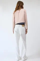 Chaqueta rosa de cuello solapa y manga larga, con cierre frontal y detalles de cremallera metálica.